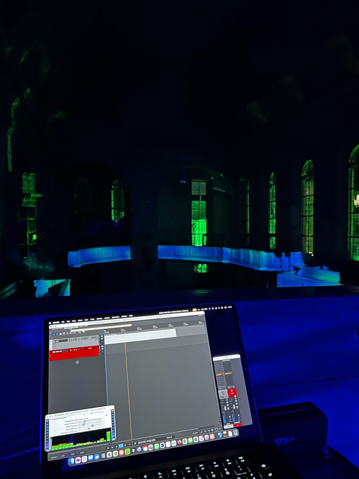 Kirchenraum bei Nacht mit grüner Projektion, im Vordergrund der Regie-Laptop